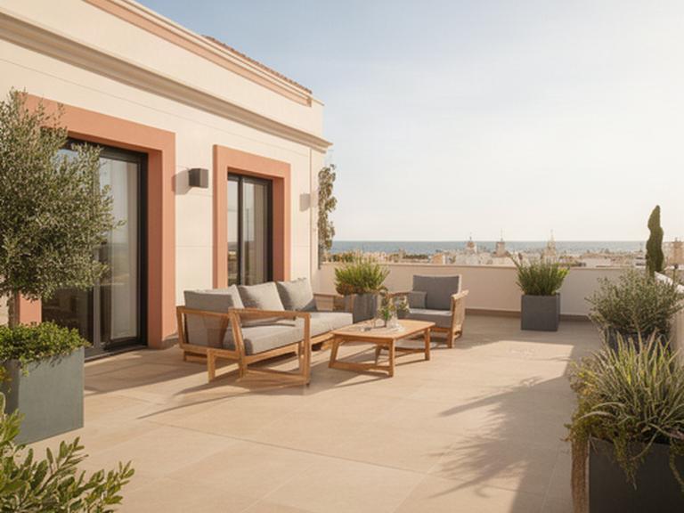 Terraza amplia junto a una vivienda en El Puerto de Santa María con pavimento porcelánico y zona de estar exterior